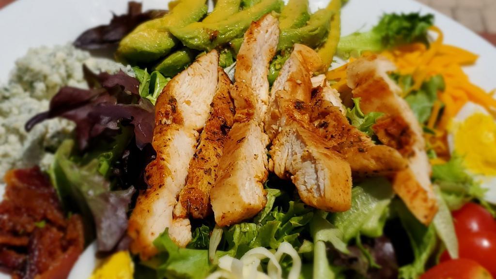 Cobb Salad · Mixed greens with grilled chicken, mozzarella, cheddar, and blue cheese, bacon bits, tomatoes, boiled egg, red onion, and sliced avocado.