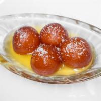 Gulab Jamun · Fried Indian cheese dough balls dipped with honey syrup and garnished with coconut flakes.