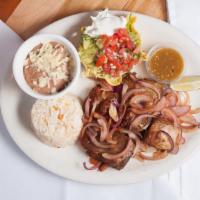 Carnitas Michoacanas · Tender pieces of deep fried pork, grilled red onions, white rice, refried beans, lettuce, pi...