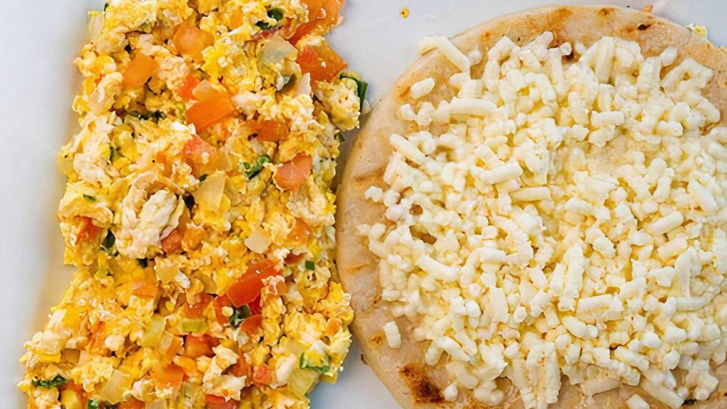 Huevos Pericos · Scrambled eggs, chopped onions, and tomatoes. Served with arepa paisa topped with white cheese.