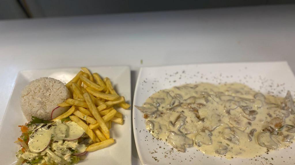 Pollo Con Champiñones · Grilled chicken breast sautéed with spices, marinated with homemade fresh mushroom sauces. Served with white rice, French fries and salad.