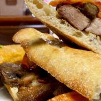 Sandwich De Chicharron · Tender Golden pork in a Baguette bread with fry sweet potato and our fresh salsa criolla