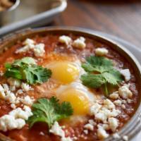 Huevos Ahogados · Two eggs, salsa roja, onions, queso fresco, cilantro, corn tortillas