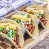 Tacos Al Pastor · Thin sliced Pork Loin Marinated in traditional spices like Achiote,  ginger, and cinnamon, g...