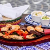 Fajita Mixta · Grilled Chicken, Steak, Vegetables, and Shrimp with Refried beans, Mexican rice, guacamole, ...