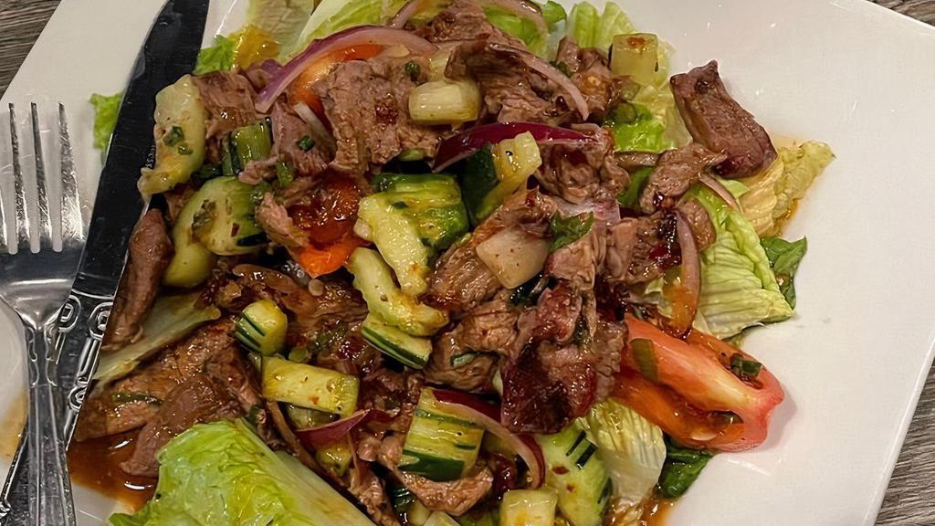 Spicy Beef Salad · Grilled marinated lean beef, tomatoes, onion, and cucumber in spicy surins sauce with romaine lettuce.