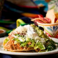 Tostada · Your choice of meat, refried beans, lettuce, tomato, queso fresco, guacamole, and crema.