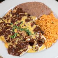 Enchiladas Tex Mex · Flour tortillas filled with your choice of meat, with chili gravy and chile con queso.