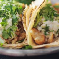 Two Fish Tacos · Two soft corn tortillas filled with marinated fish and salsa mexicana. Served with rice, bea...