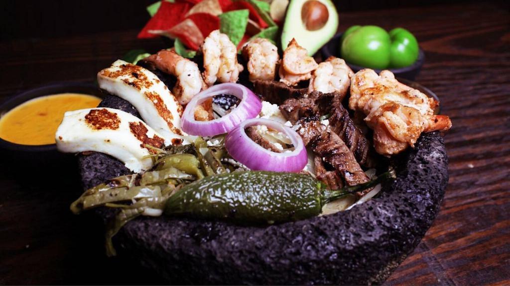 Molcajete · This favourite filled with carne asada, chorizo and grilled chicken, and topped with bell peppers and onions, green tomatillo sauce pico de gallo, ranchero cheese, melted cheese and jalapeño, and don't forget warm tortillas rice and beans on the side.
