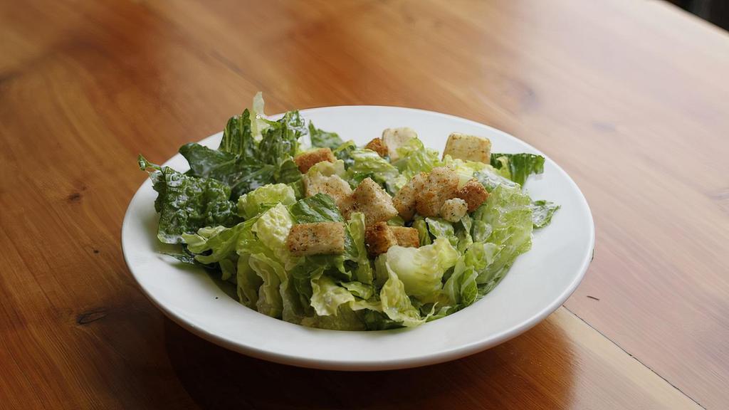 Caesar Salad · Crispy romaine lettuce tosssed in house made Caesar dressing, shredded parmesan, and crispy croutons.