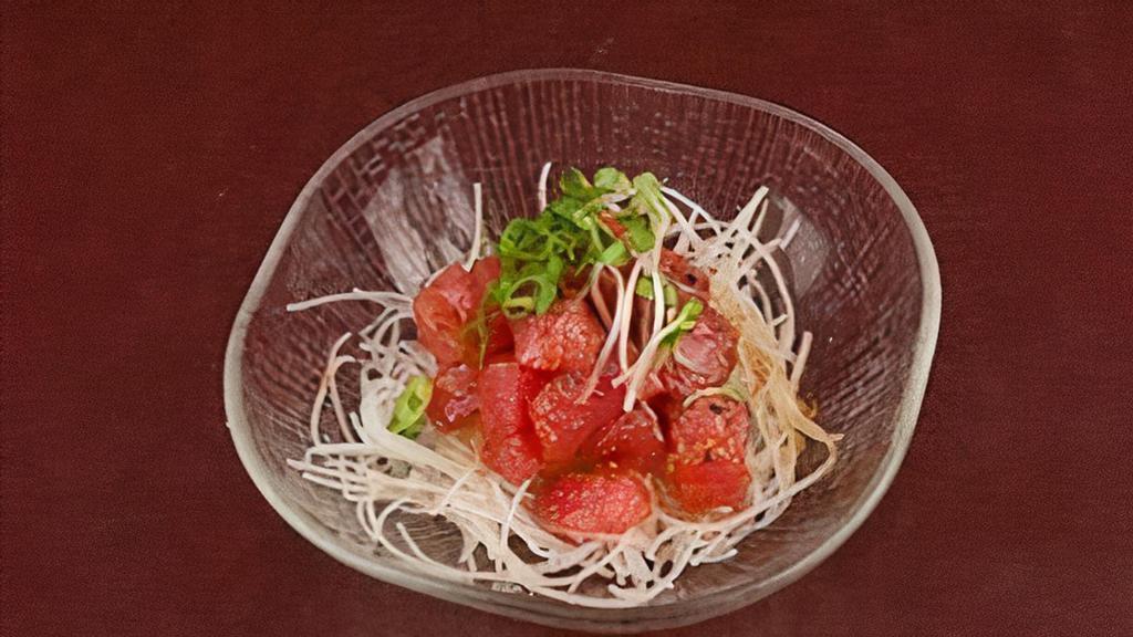 Tuna Poke · Bite-sized cuts of tuna tossed with soy, sesame oil, hot chili oil and shichimi pepper. Topped with chives and served on a bed of grated daikon.