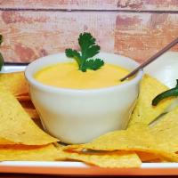 Chile Con Queso 8Oz (With Chips) · Melted yellow cheese mixed with bell peppers and accompanied by a complementary bag of chips.