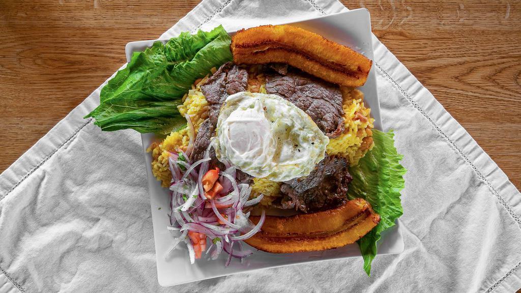 Tacu Tacu A Lo Pobre · Militer a combination of rice and beans served with fried plantains, egg, salsa criolla, and marinated steak.