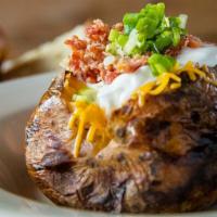 Baked Potato · Fresh Baked Potato Loaded With Butter, Cheese, Sour Cream, Bacon Bits and Green Onions.