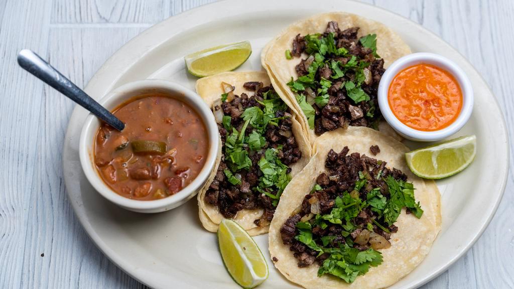 Street Tacos · Three corn tortilla tacos, with sautéed beef fajita, onion, and fresh cilantro. Served with charro beans.