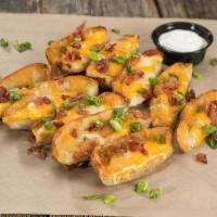 Potato Skins · Hot potato skins loaded with cheddar jack cheese, bacon, and scallions. Served with sour cre...