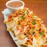 Buffalo Chicken Nachos · Tortilla chips piled skyscraper high with queso, tomatoes, scallions, sour cream, cheddar ja...