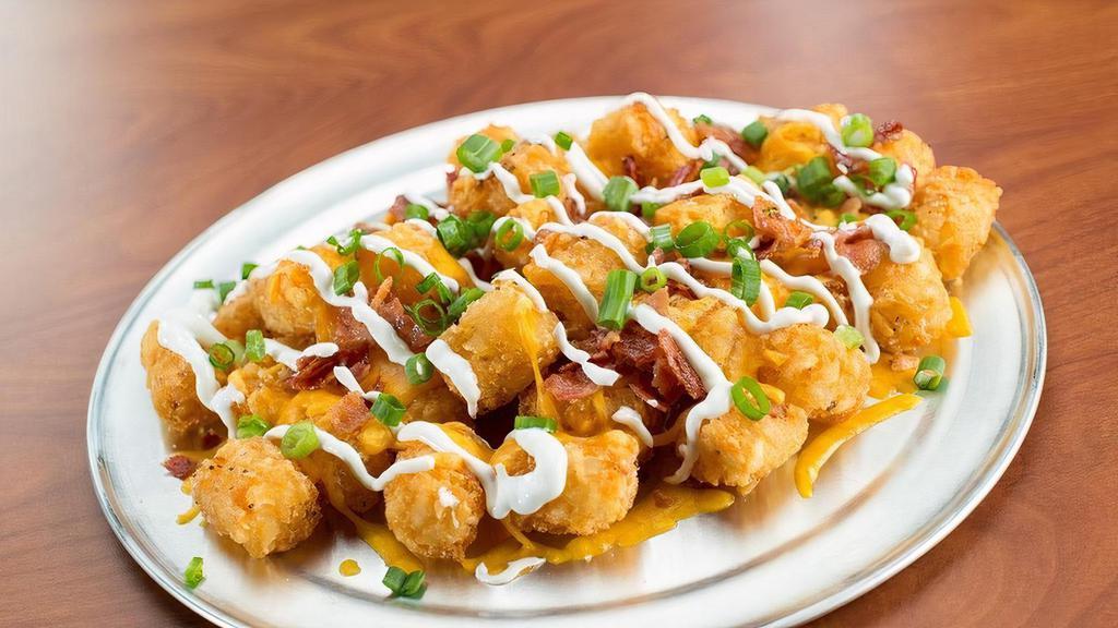 Loaded Tots · You gonna eat your tots? We serve ’em nice and crispy with cheddar jack cheese, bacon, sour cream, and scallions.