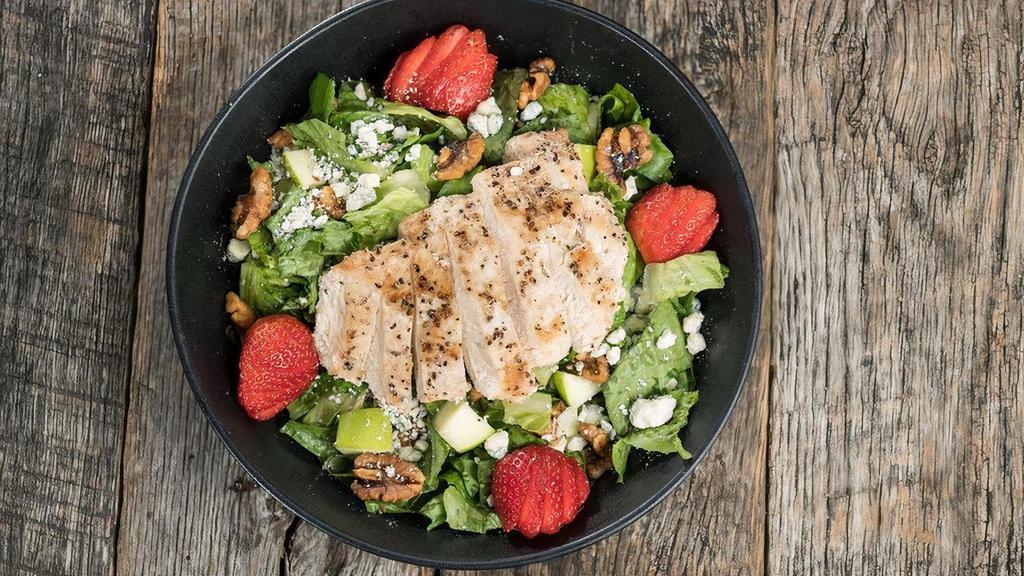 Chicken Apple Walnut Salad · Garden romaine topped with Granny Smith apples, strawberries, candied walnuts, bleu cheese crumbles, and freshly grilled chicken. Tossed with mango citrus vinaigrette. It’s as amazing as it sounds.