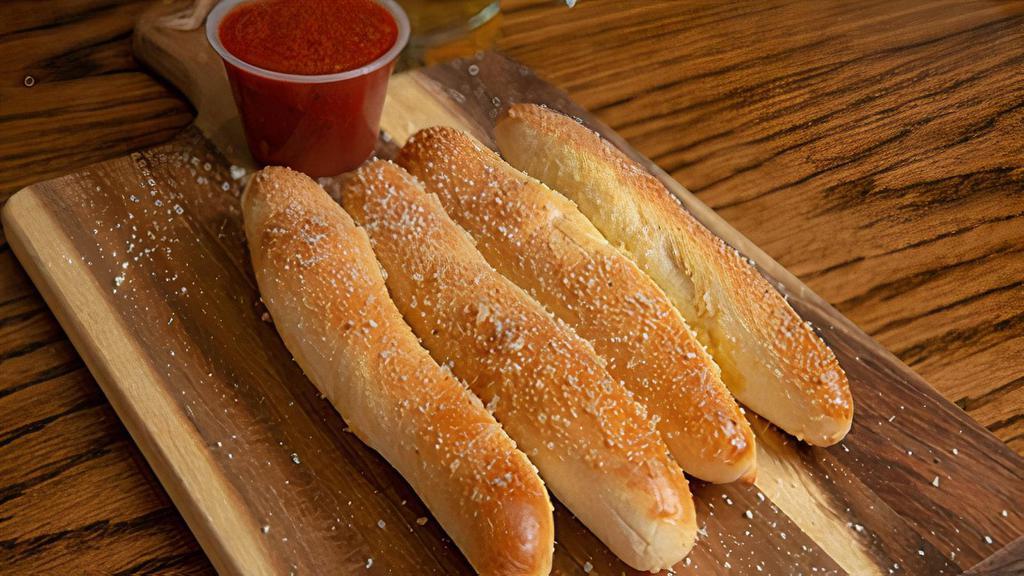 Large Bread Sticks · Our famous bread sticks topped with garlic butter and our parmesan romano cheese mix. Served with a side of our signature marinara sauce.