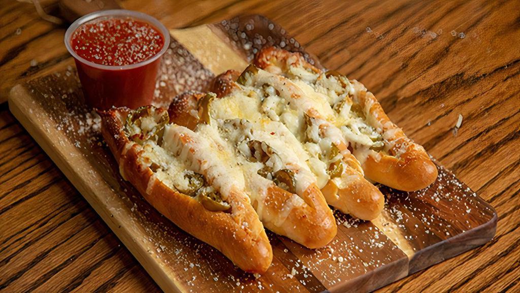 Small Spicy Sticks · Our famous bread sticks with jalapenos and mozzarella cheese. Topped with garlic butter and our parmesan romano cheese mix. Served with a side of our signature marinara sauce.