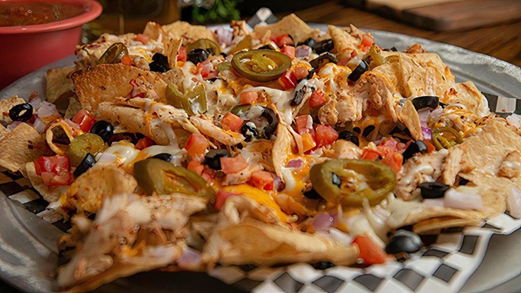 Large Chicken Nachos · A LARGE plate of corn chips piled with your favorites. Chicken, onions, tomatoes, black olives, jalapenos, mozzarella cheese, and cheddar cheese. Served with a side of our signature salsa.