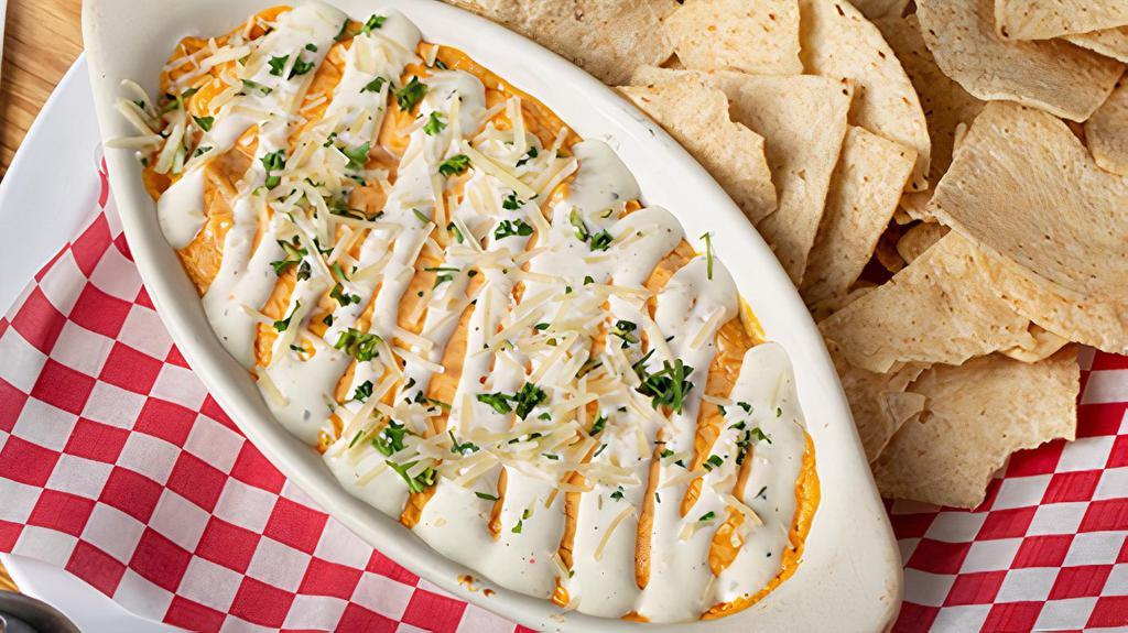 Buffalo Chicken Dip · A blend of cheeses with buffalo chicken baked to a simmering boil. Finished with a drizzle of ranch and topped with fresh parmesan.