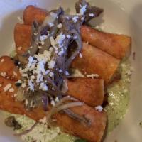 Brisket Enchiladas · 4 mashed potato enchiladas dipped and flash fried in guajillo sauce on a bed of poblano sauc...