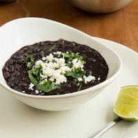 Black Bean Soup · Salvadorian style creamy black bean soup with queso fresco and cilantro as a garnish.