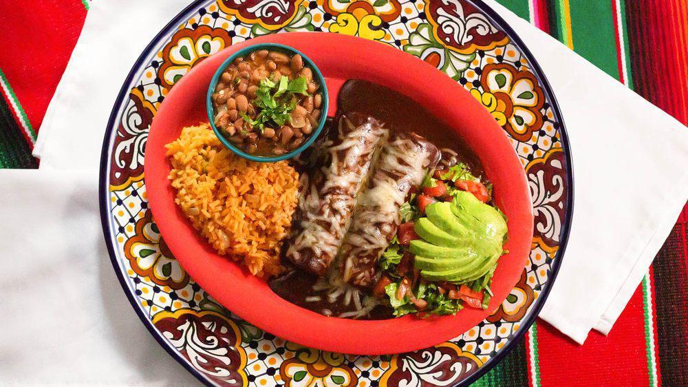 Mole Enchiladas · Two chicken enchiladas topped with mole sauce. Includes Spanish rice, refried or charro beans, and two flour tortillas.