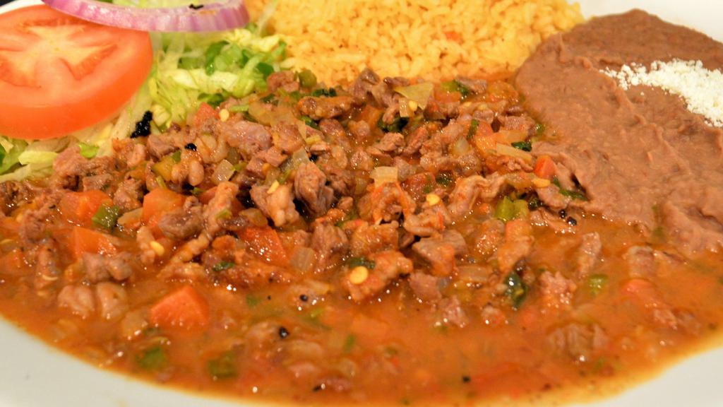 Bistec A La Mexicana · Chopped beef steak grilled with our special salsa and tomatoes, onions and jalapeños, served with rice and refried beans, side of salad and tortillas