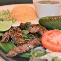 Fajita · Beef or chicken fajita served over a bed of grilled onions and chile toreado on a hot skillet.