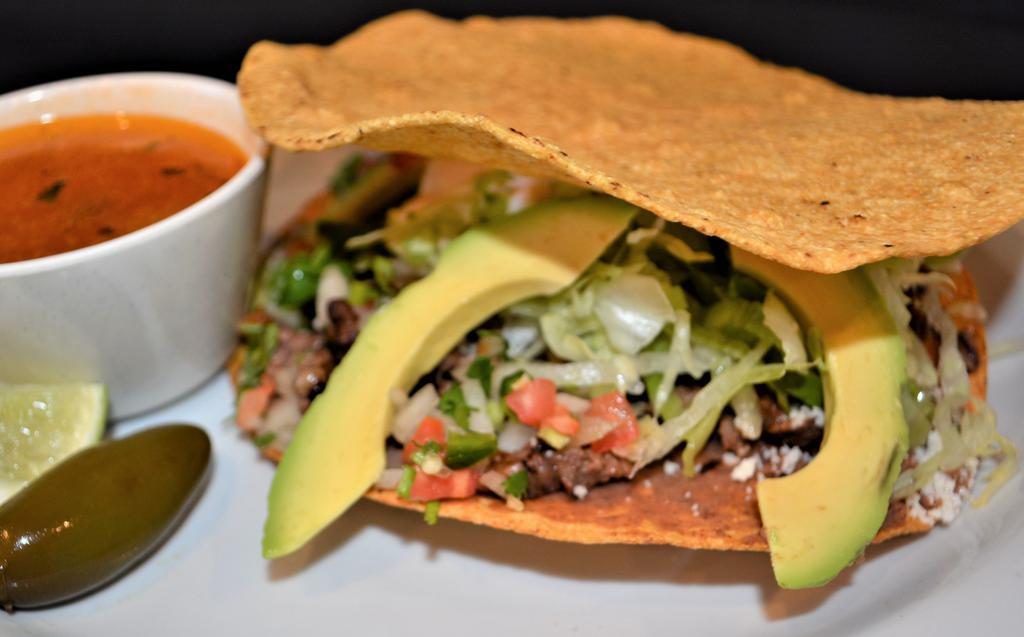 A La Mexicana · Chopped Bistec with pico de gallo, avocado, refried beans, cheese, lettuce and Mexican cream in two big tostadas.