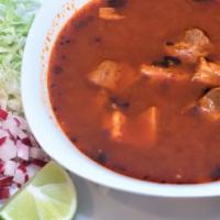 Pozole · Traditional pork stew with hominy, dried chiles, red onions, cabbage, radishes, and spices
