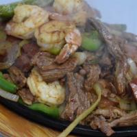 Parrillada De Fajita Mixta · Beef, shrimp, sausage, rice, beans, nopales, and pico de Gallo.