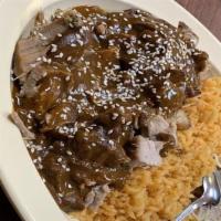 Mole Con Carnitas · Fried pork with mole, rice and beans.