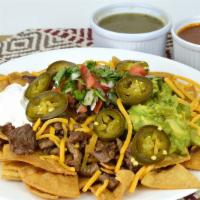 California Nachos · Tostada chips piled high layers with your choice of meat. Topped with beans, cheese, pico de...