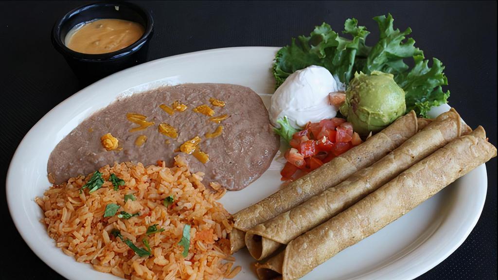 Flautas · Two chicken flautas rolled in corn tortillas fried and lightly topped with ranchero sauce or chile con queso, sour cream & guacamole. Rice and beans.