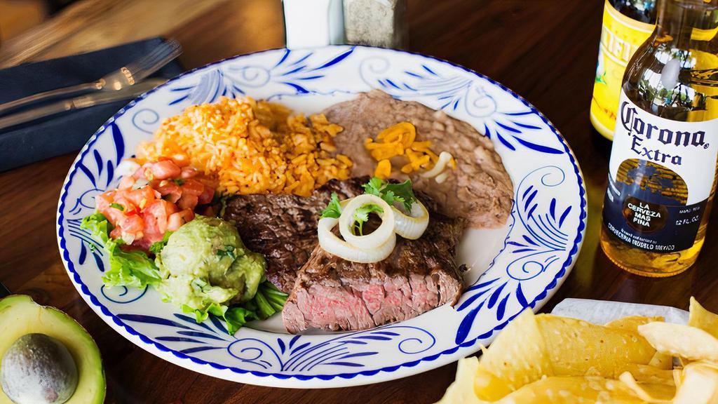 Carne Asada · Tender sirloin steak, marinated & grilled to perfection. Served with guacamole, pico de gallo, rice & beans.