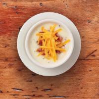 Country Potato Soupe · Our creamy potato soupe accented with leeks and onions. Garnished with cheddar cheese and ch...