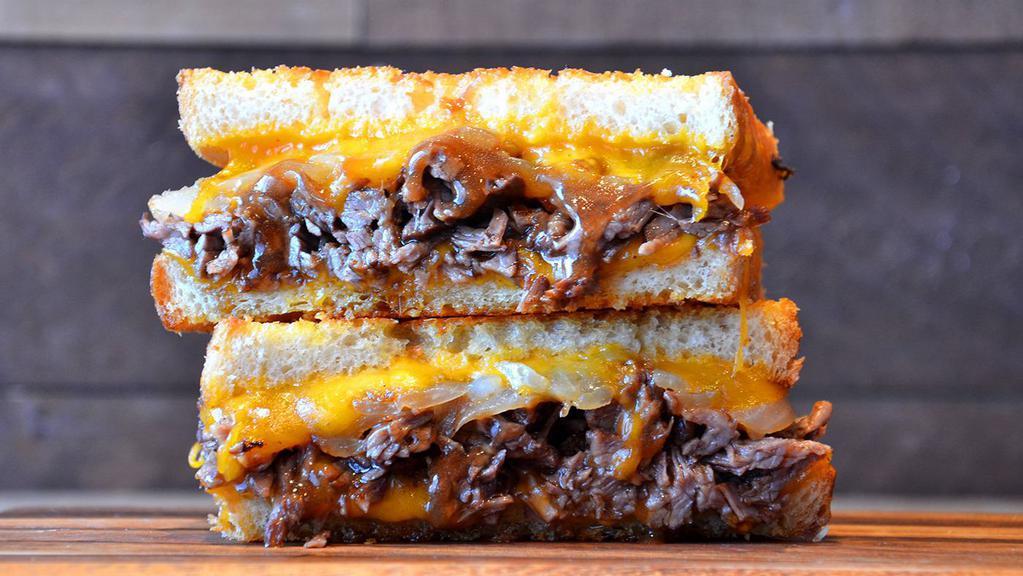 Smoked Brisket Grilled Cheese · Smoky beef brisket, Provolone and cheddar cheese and grilled onions on artisan bread with garlic butter.