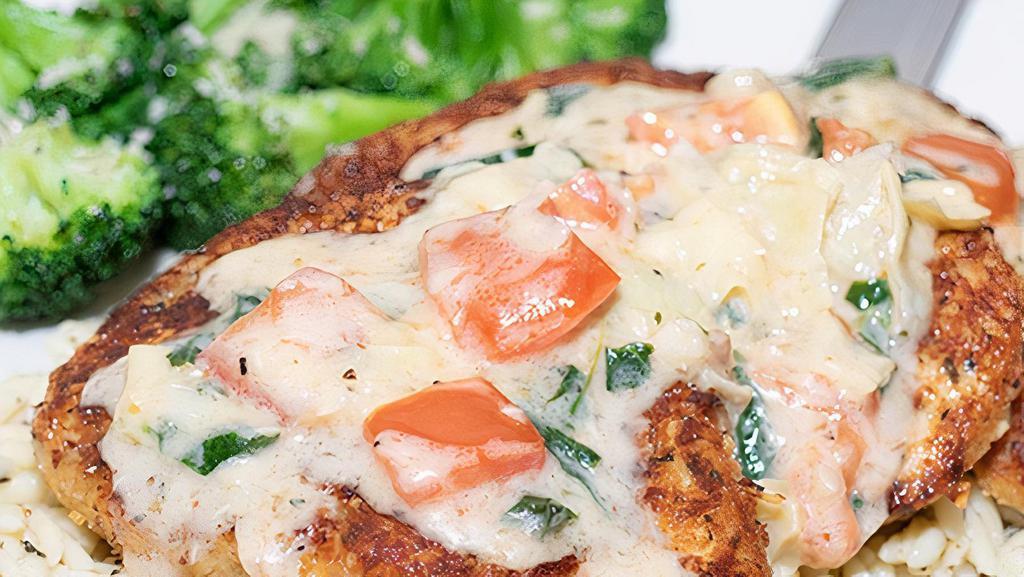 Herb Crusted Chicken · Herb parmesan crusted chicken, topped with lemon butter sauce, tomatoes, fresh spinach, and artichoke hearts. Served over orzo pasta with a side of sautéed broccoli.