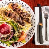 Light - Steak Skewers (Souvlaki) · Two char-grilled steak skewers over rice with Greek salad.
