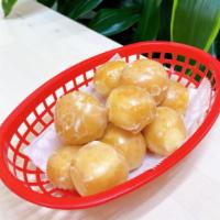 Glazed Donut Holes (1 Dz) · A bag filled with 12 pieces of glazed donut holes.