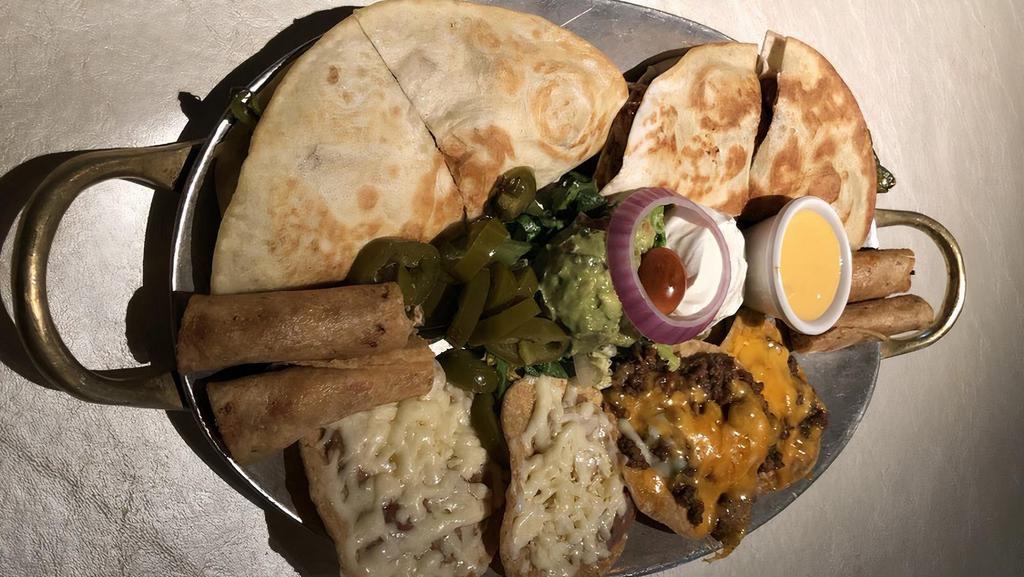 Mena'S Platter · Two bean and cheese nachos, two beef and cheese nachos, one pastor quesadilla, one brisket quesadilla, and four chicken flautitas. Served with guacamole, queso dip, and sour cream.