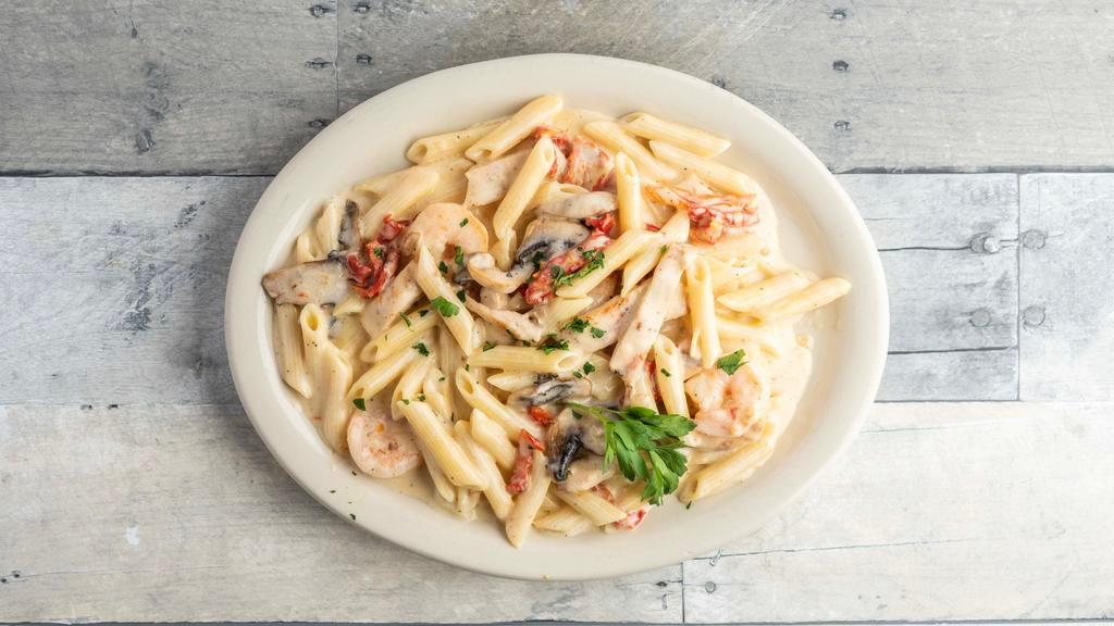 Penne Rustica · Penne pasta with grilled chicken, shrimp, mushrooms & sun-dried tomato in a creamy roasted garlic sauce.