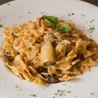 Farfalle Modo Mio · Bowtie pasta sautéed with pancetta, garlic, mushrooms, and artichoke hearts in a creamy vodk...