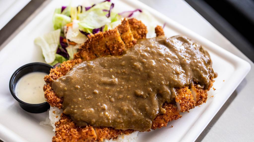 Pork Katsu Curry · Pork Katsu Curry is an absolute favorite. Panko breadcrumb coated pork served with a traditional Japanese Curry sauce over the top. The meal comes with Calrose rice and a side salad.