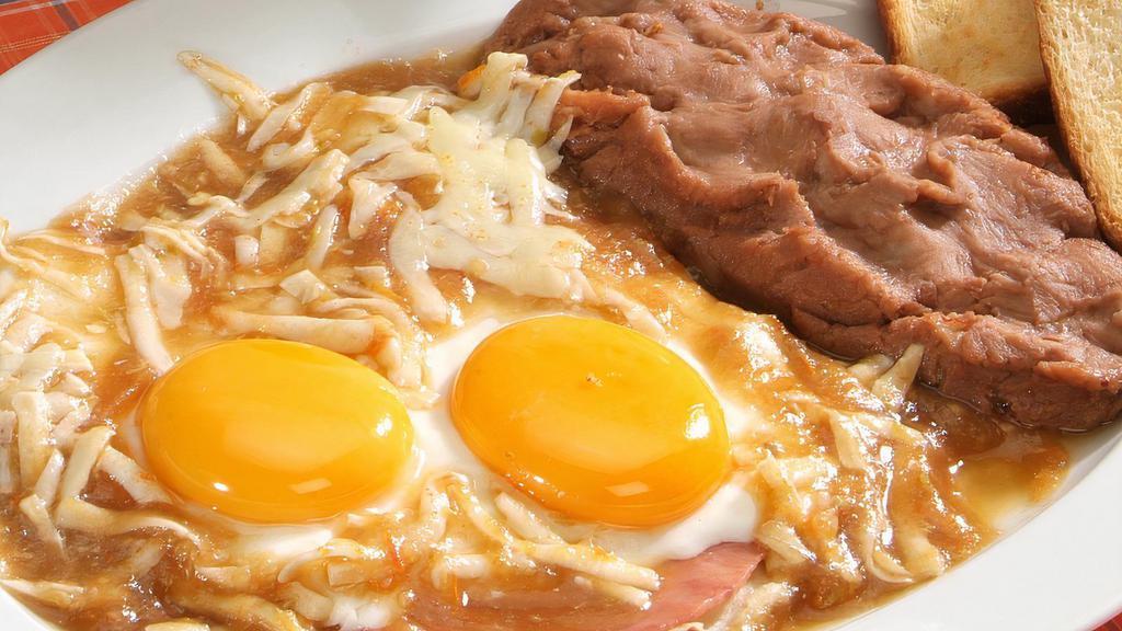 Rancheros Eggs · 2 Fried eggs over ham & corn tortilla, cover with sauce topped melted cheese, red or green chilaquiles, refried beans,